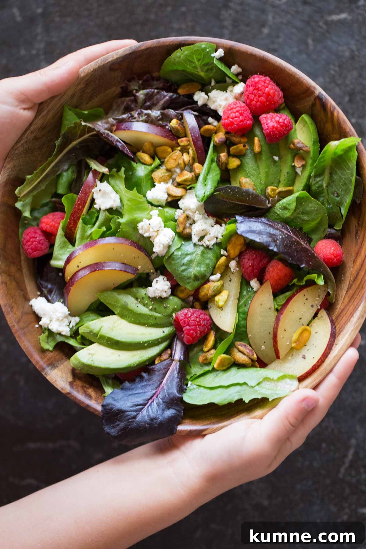 Summer Fruit Salad with Goat Cheese & Pistachios for Entertaining 2 Summer Fruited Salad with Goat Cheese and Pistachios in a wood bowl.