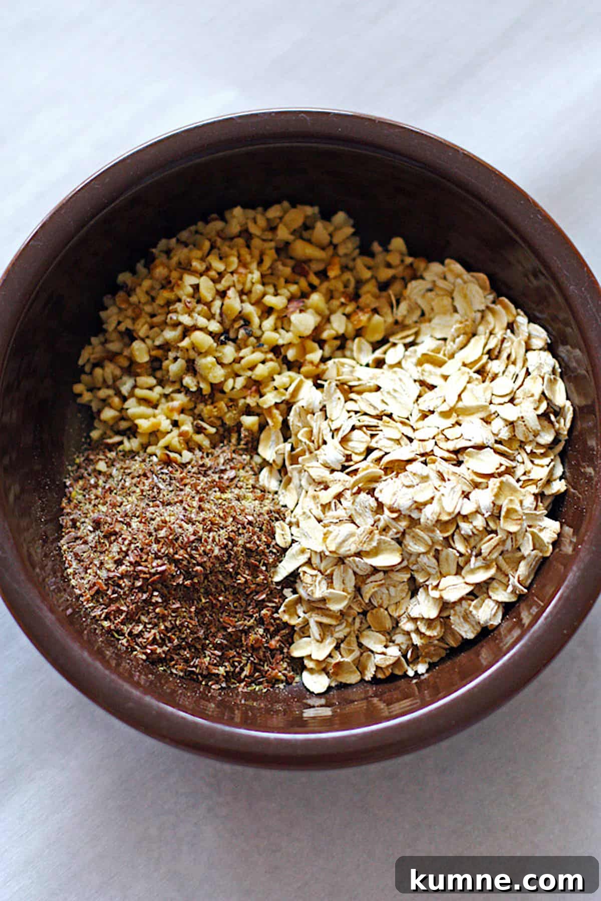 No-Bake Peanut Butter Energy Balls Recipe for Quick Snacks 3 A brown bowl with dry the ingredients for peanut butter energy balls - ground flax seeds, oats, and walnuts.