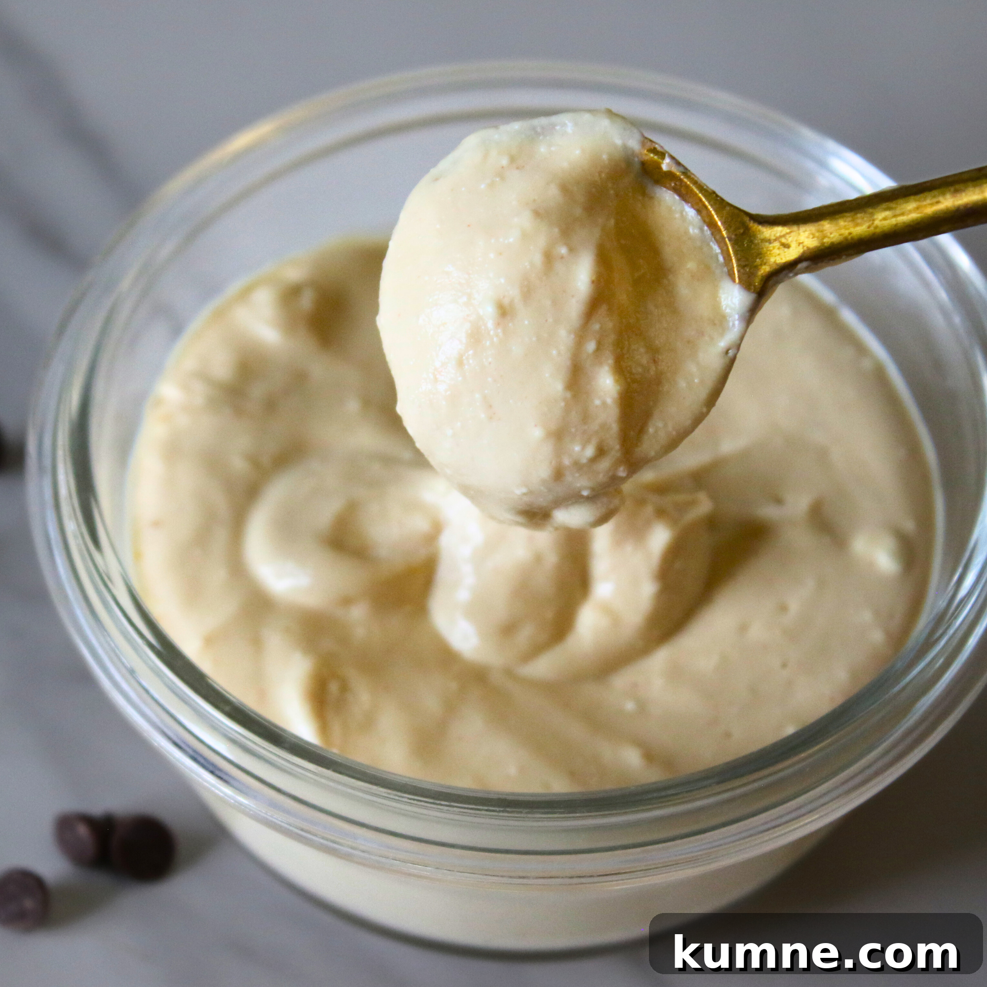 Light and Creamy Protein Fluff Dessert Recipe 4 Peanut butter protein fluff in a glass bowl with a bronze spoon.
