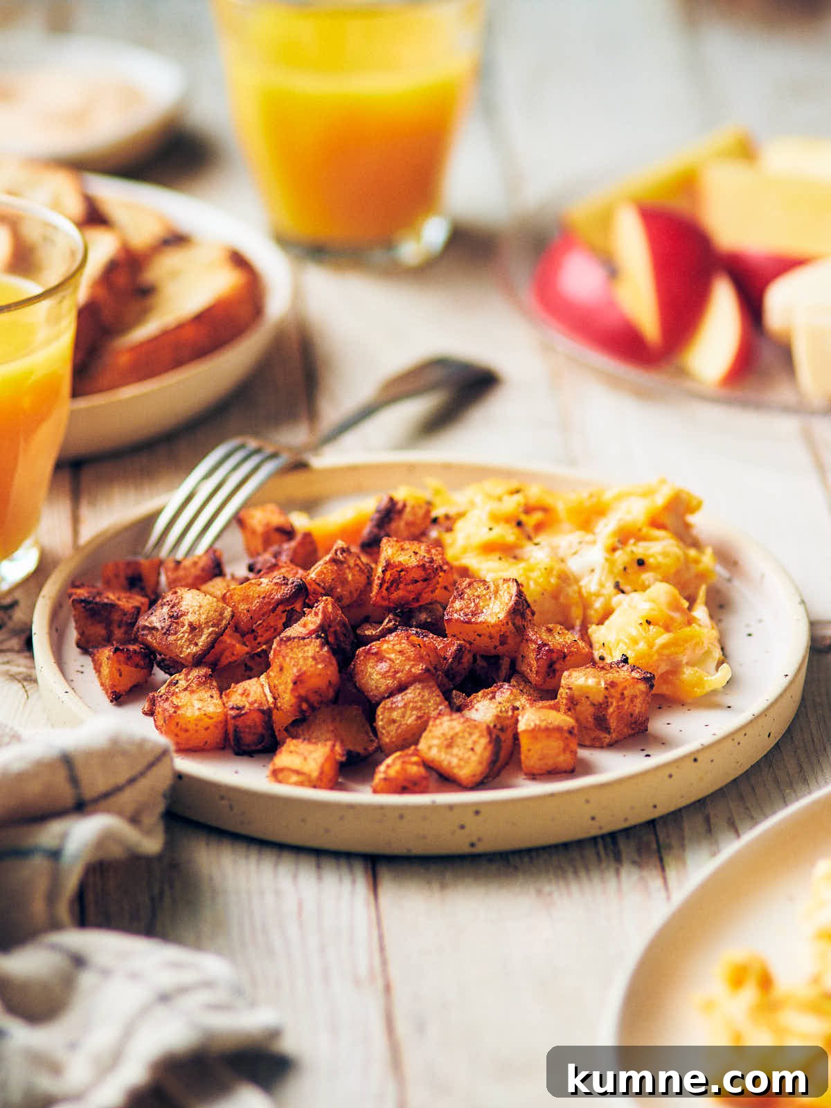 A plate of crispy air fryer breakfast potatoes with soft scrambled eggs.