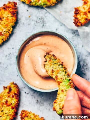 A crispy avocado fry being dipped into vegan chipotle mayo