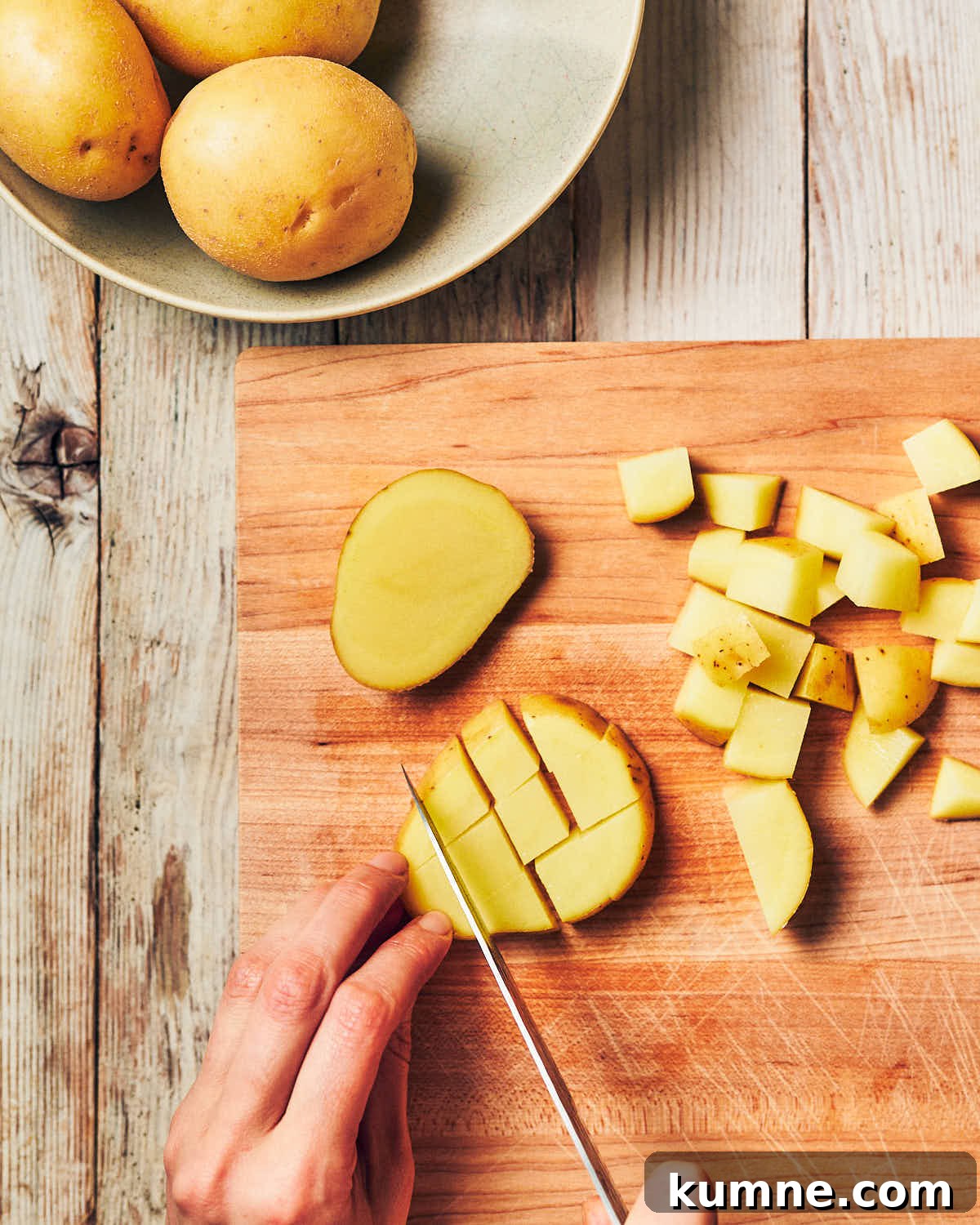 Potatoes on a cutting board being diced for air fryer breakfast potatoes.