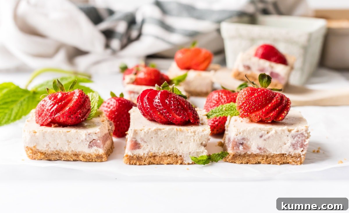 strawberry cheesecake bars garnished with fresh strawberries