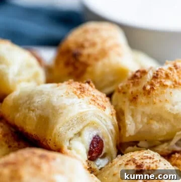 Cheesy Puff Pastry Pigs in a Blanket Recipe 11 Strait on shot of pigs in a blanket on platter.
