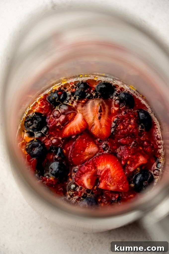 Berry Sangria and Refreshing Non-Alcoholic Berry Mocktail 11 Aerial photo of the fruit mixture for berry sangria in a glass pitcher.