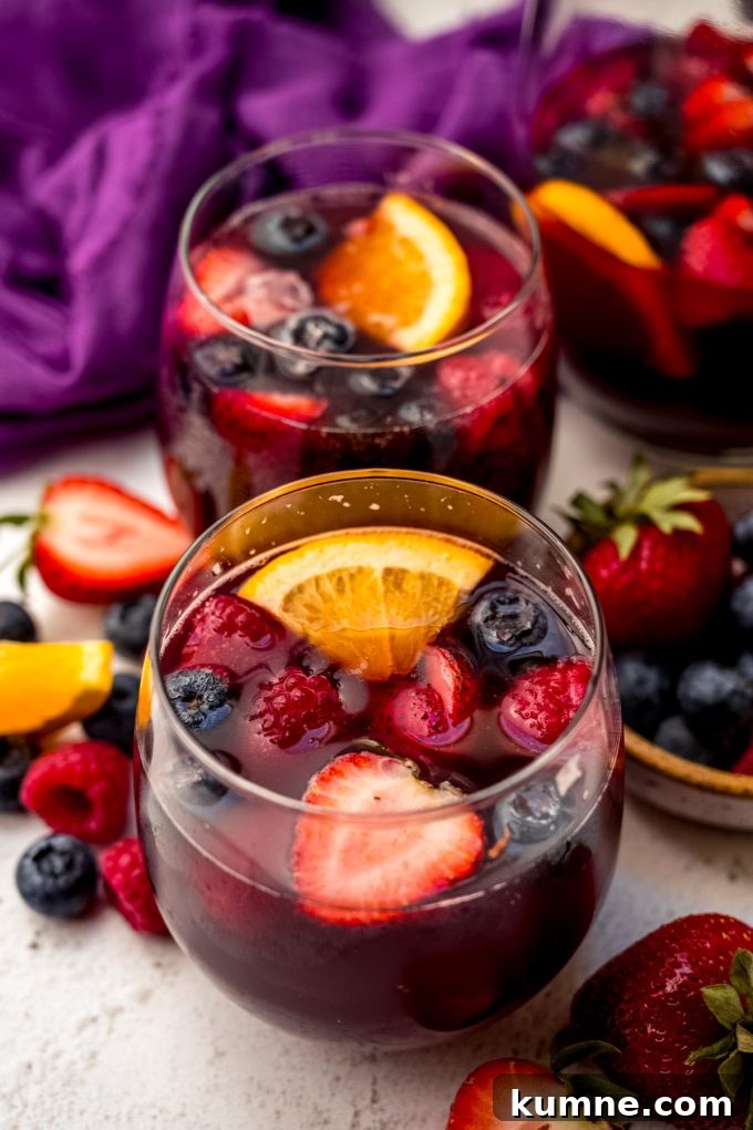 Berry Sangria and Refreshing Non-Alcoholic Berry Mocktail 18 Two glasses of berry sangria on a surface.