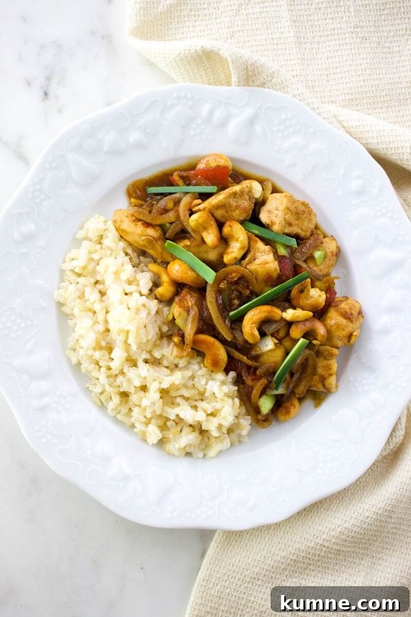 thai chicken with cashews and white rice on a white plate