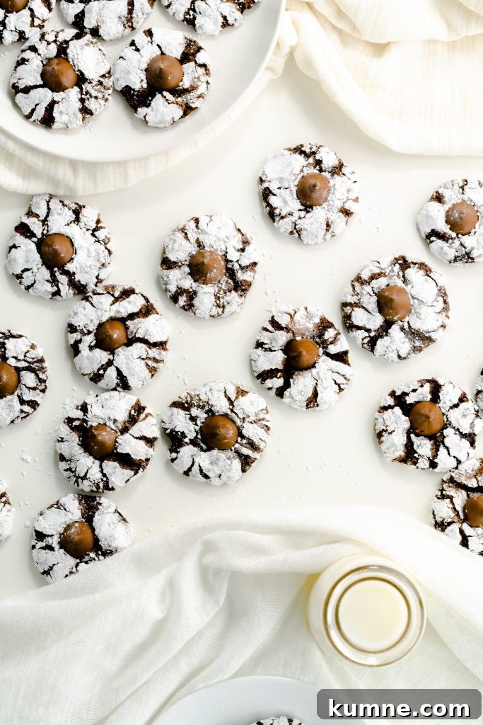 Scattered chocolate cookies with kisses on white background.