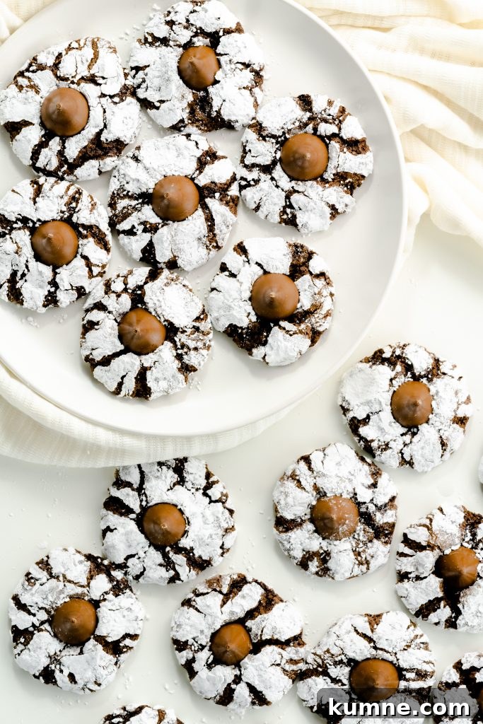 Chocolate crinkle kiss cookies on a plate and on the table.