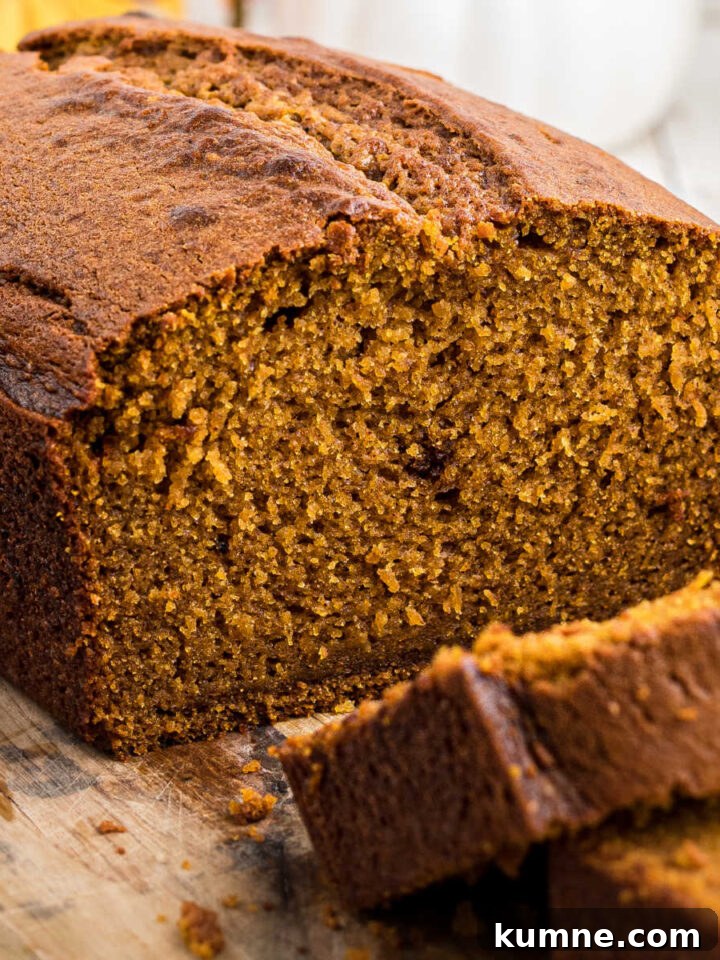 Close up side view of an Amish Pumpkin bread with slices taken from it.