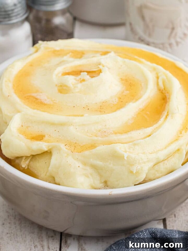 Side shot of a bowl of amish mashed potatoes cropped square.
