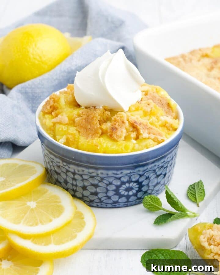 A bowl of lemon dump cake topped with whipped cream.