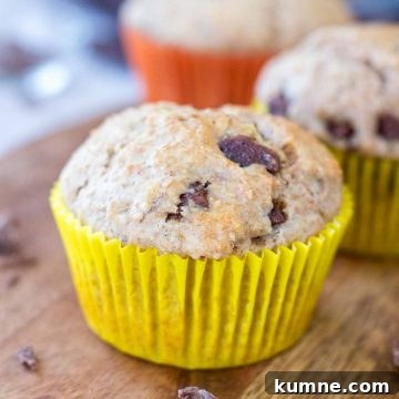 Banana chocolate chip muffins served on a wooden plate.
