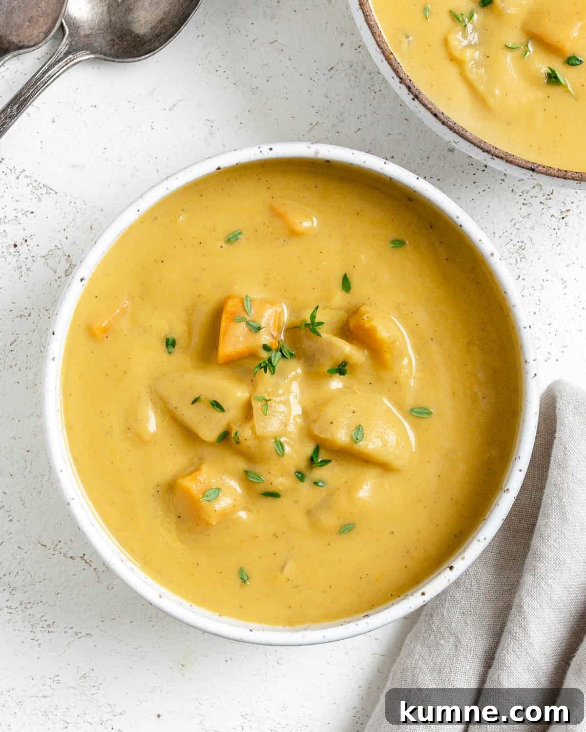 completed Roasted Delicata Squash and Sweet Potato Soup in a white bowl against a light background