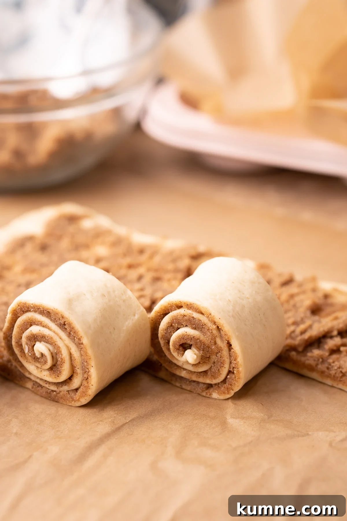 Cinnamon rolls being rolled up.