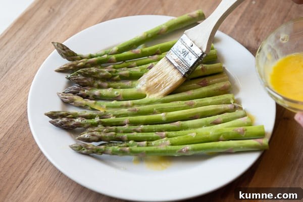 Crispy Keto Air Fryer Asparagus Recipe 5 Brushing Asparagus with beaten egg