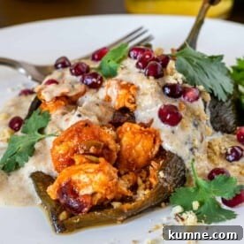 close up of chile en nogada on white plate with fork