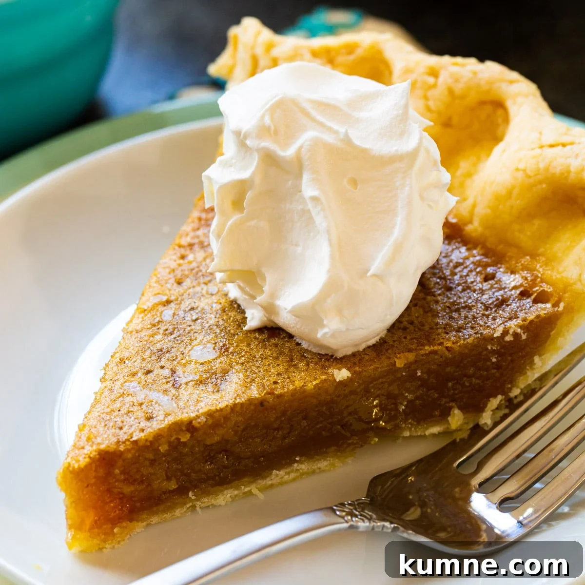 Slice of caramel chess pie topped with whipped cream.