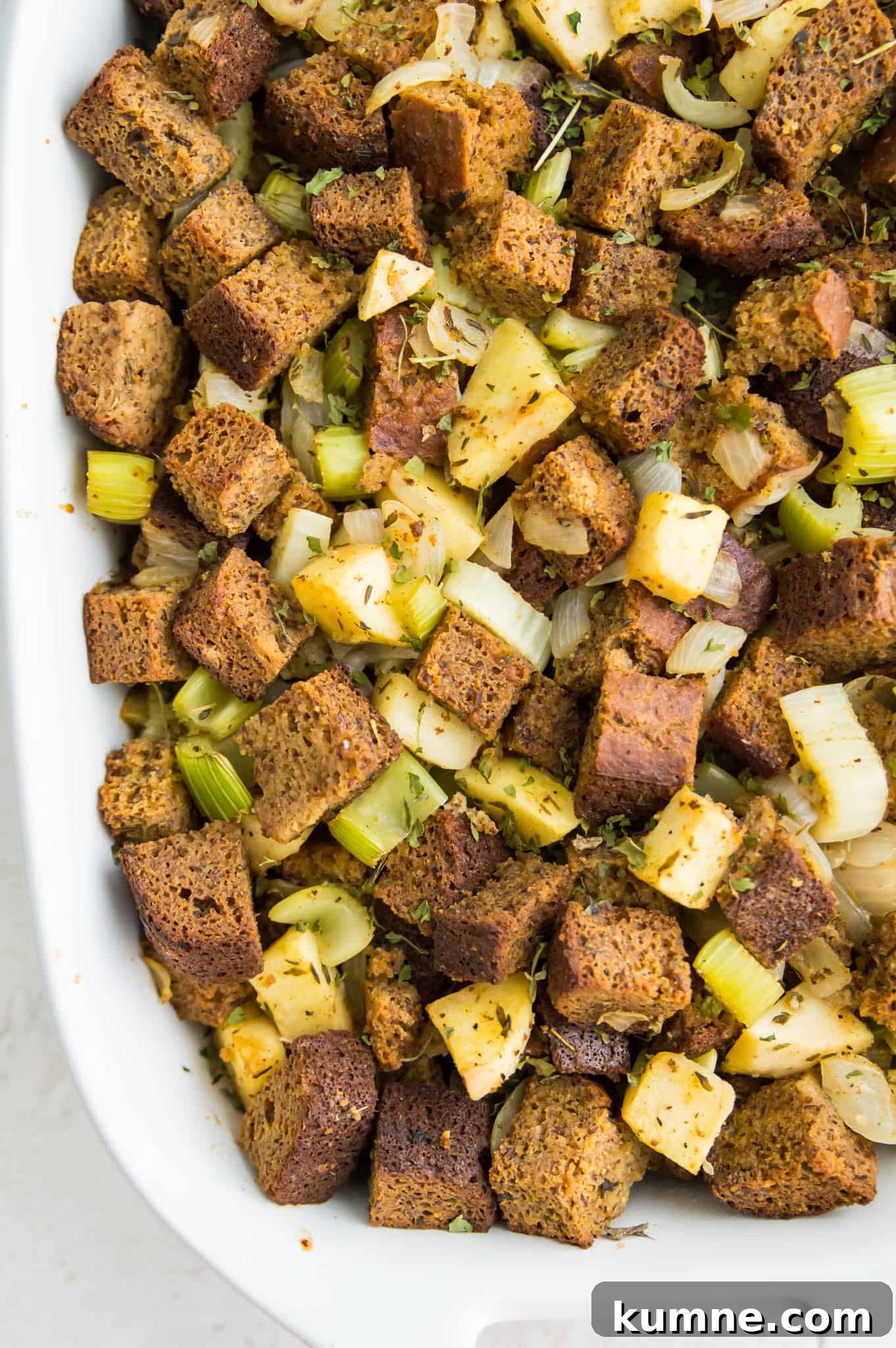 Gluten-Free Paleo Stuffing Made with Paleo Bread 2 A casserole dish filled with stuffing made with bread cubes, apples, onions and celery.