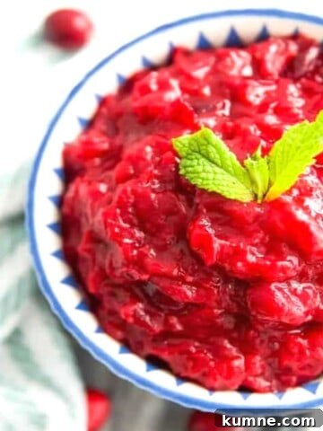 A bowl of sugar free cranberry sauce with mint leaves on top for garnish.