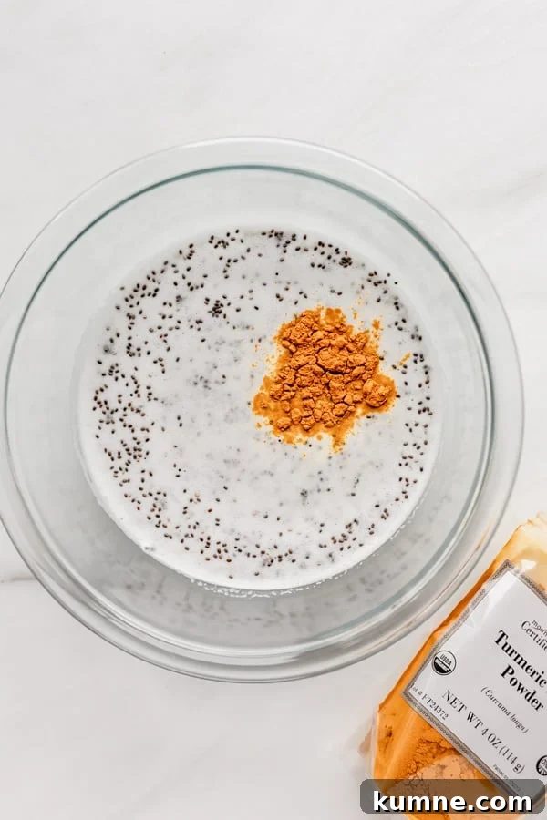 Turmeric Golden Milk Chia Pudding Recipe 5 A clear mixing bowl with coconut milk, chia seeds and turmeric in it