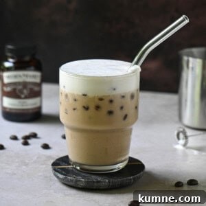 Iced Vanilla Bean Latte Recipe Using Real Vanilla Extract 14 Eye-level view of a vanilla bean latte on a brown surface.