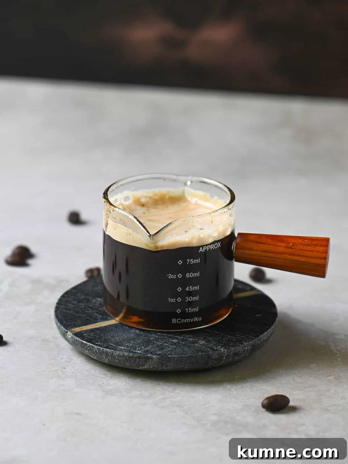 Iced Vanilla Bean Latte Recipe Using Real Vanilla Extract 4 Espresso into a small clear glass holder with a wooden handle.