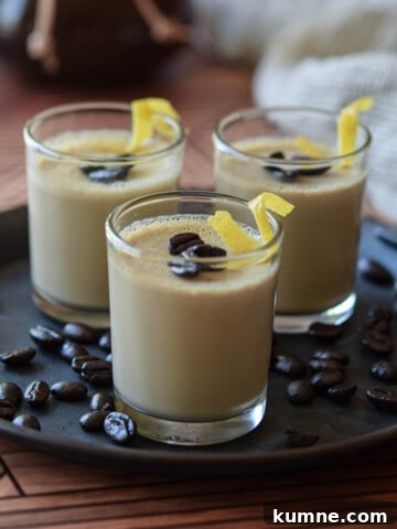 Espresso panna cotta in small glass jars topped with coffee beans and lemon rind.