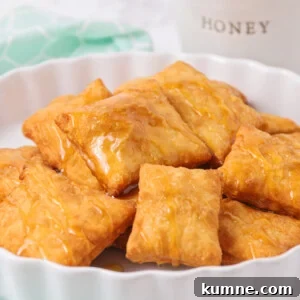 Sopapillas on a platter drizzled with honey.