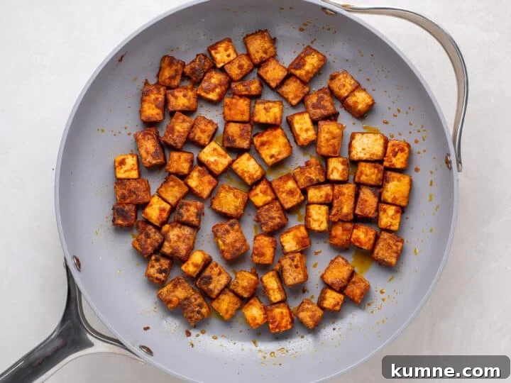 Apricot Harissa Tofu with Couscous Pilaf — Sweet and Spicy Flavor 11 crispy tofu cubes browning in a skillet for apricot harissa tofu
