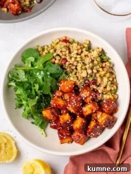 apricot harissa tofu served with couscous pilaf and greens in a Mediterranean-inspired bowl