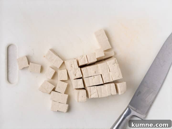 Apricot Harissa Tofu with Couscous Pilaf — Sweet and Spicy Flavor 7 extra-firm tofu cut into small cubes on a cutting board