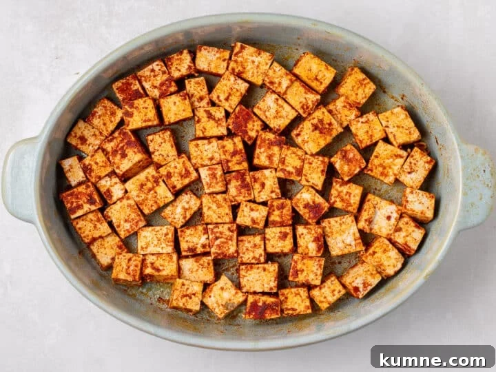 Apricot Harissa Tofu with Couscous Pilaf — Sweet and Spicy Flavor 9 seasoned cubes arranged in a baking dish before cooking