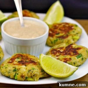 Canned salmon patties on white plate, with dip in the middle and lime wedges