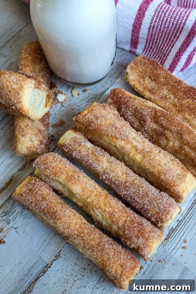 Crispy Oven-Baked Churros Recipe you Can Make at Home 2 easy baked churros with a glass of milk for serving
