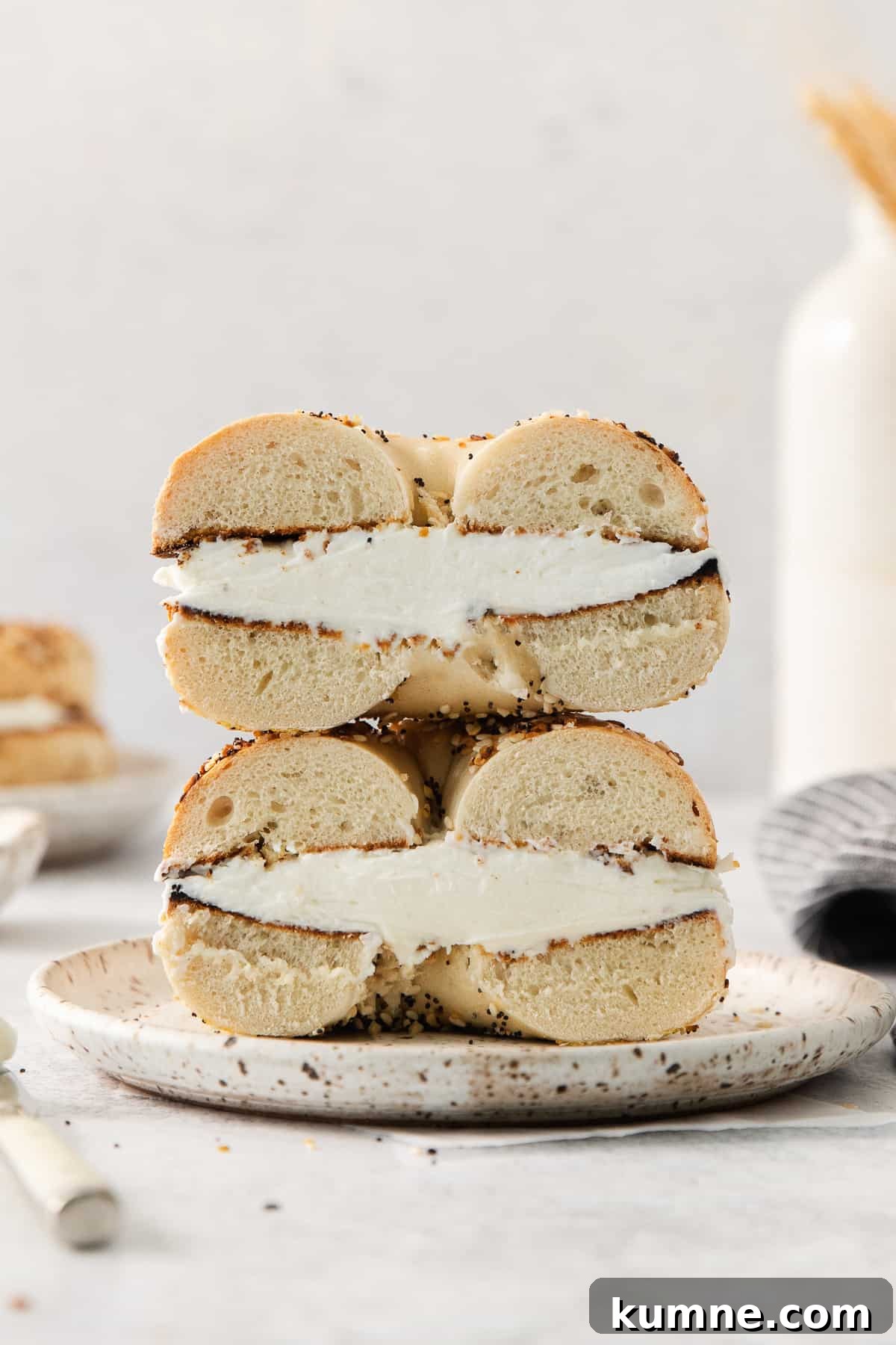 a stack of bagel sandwiches with cream cheese on top.