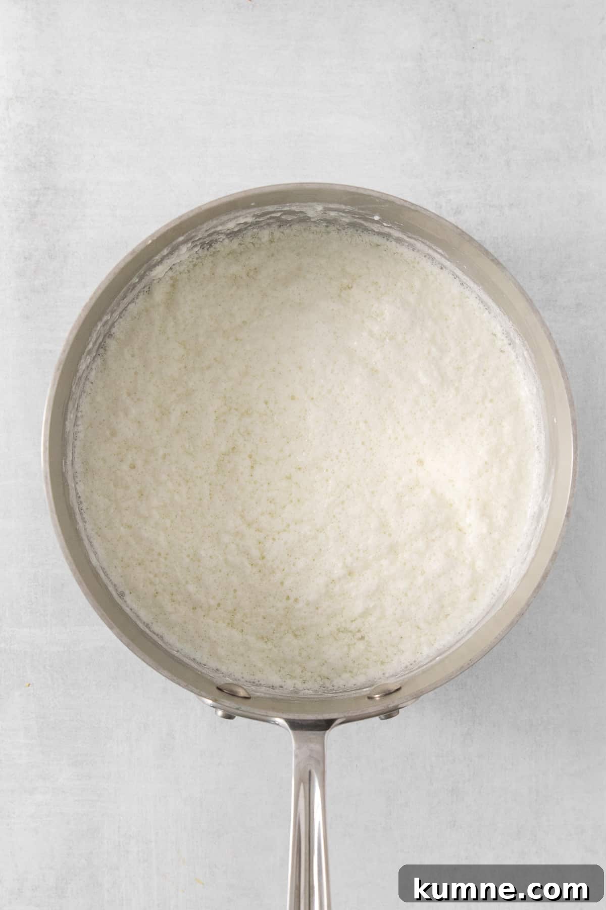 white rice in a pan on a white background.