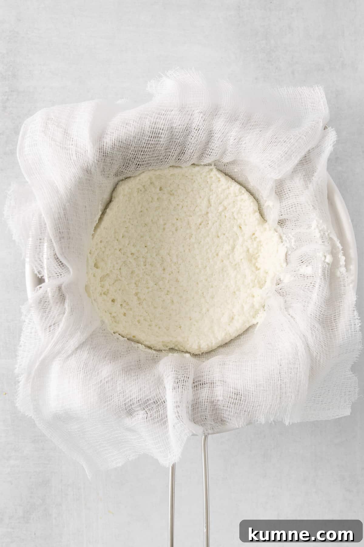 ricotta cheese in a cloth bag on a white background.