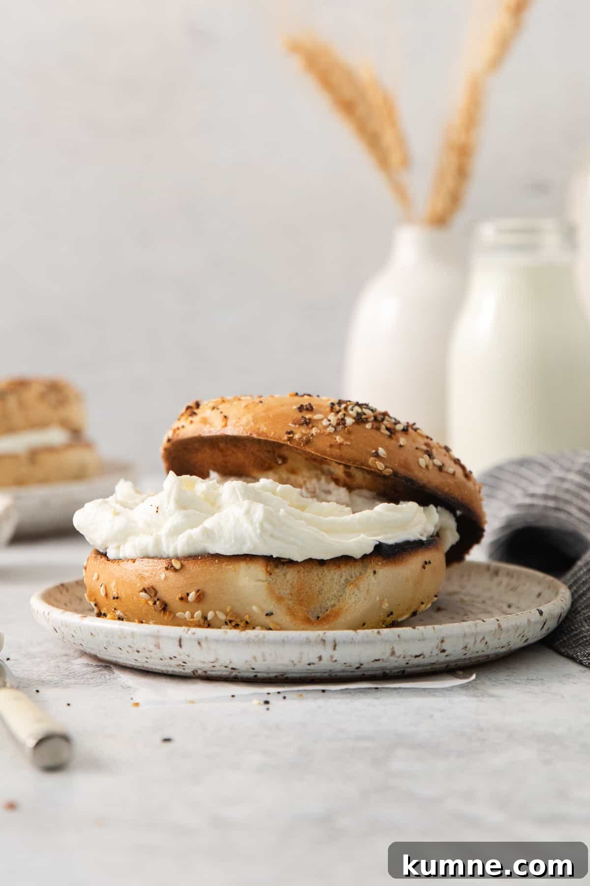a bagel with cream cheese on a plate.