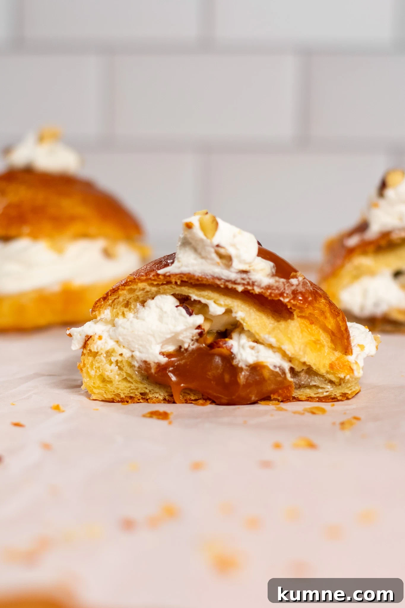 Salted Caramel Hazelnut Fastelavnsboller Recipe 3 A cross section of a Danish pastry bun filled with hazelnut, whipped cream, and salted caramel.