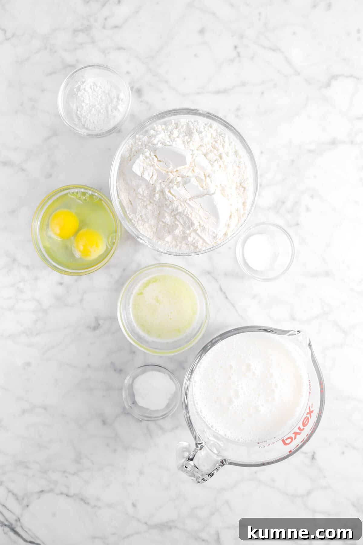 Fluffy Homemade Buttermilk Pancakes Recipe for Perfect Mornings 6 baking powder, eggs, flour, salt, melted butter, baking soda, and buttermilk on marble counter