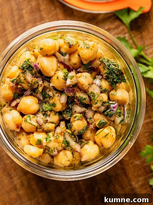 Elote Pasta Salad Inspired by Mexican Street Corn 13 Marinated chickpeas in a mason jar with herbs, oil and seasoning sitting on a wooden board.