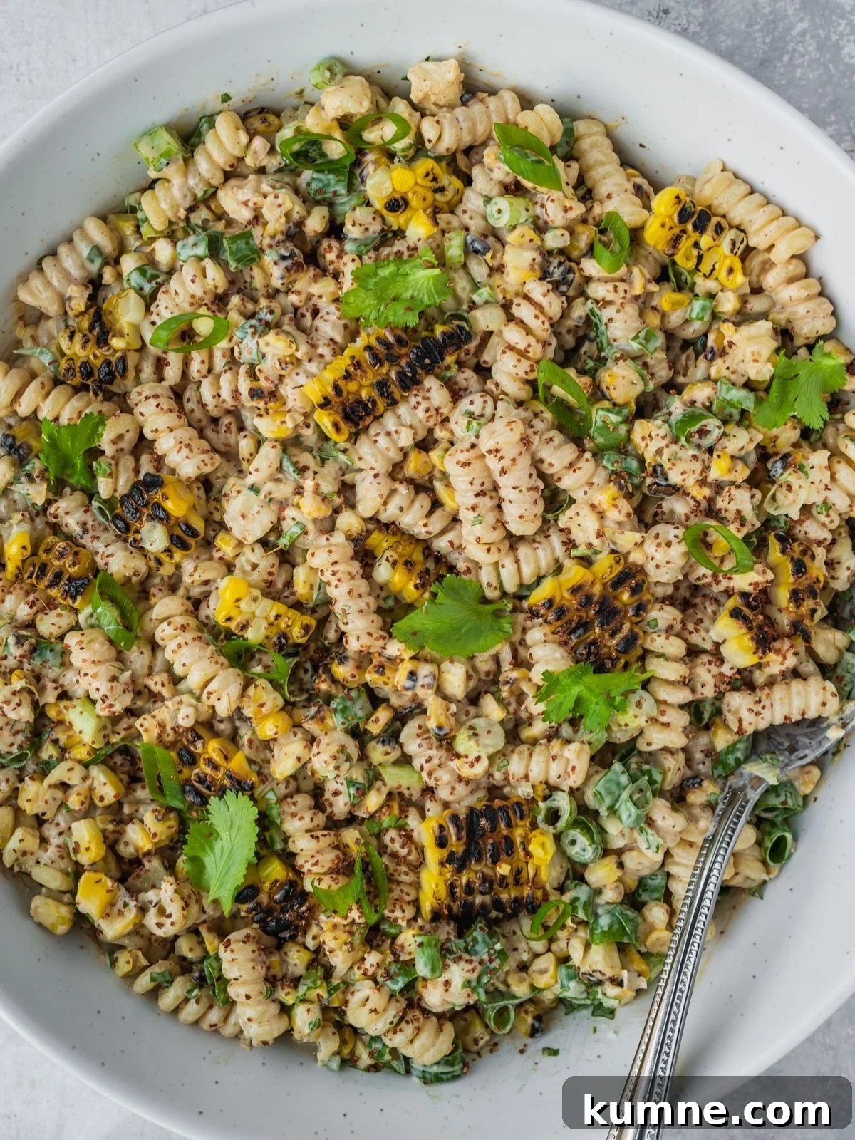 Elote Pasta Salad Inspired by Mexican Street Corn 9 Elote pasta salad in a large bowl garnished with tajin, fresh cilantro and chopped green onion.