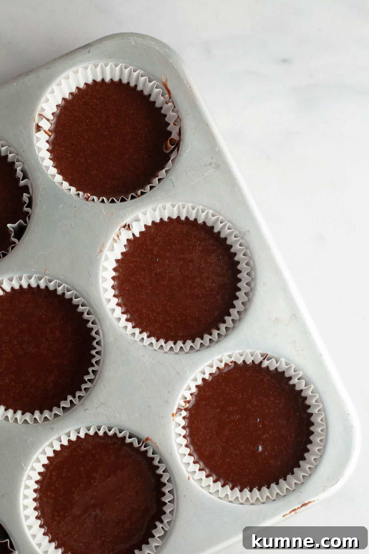 Moist Chocolate Cupcakes with Cream Cheese Frosting Recipe 7 Unbaked chocolate cupcakes in a cupcake pan.