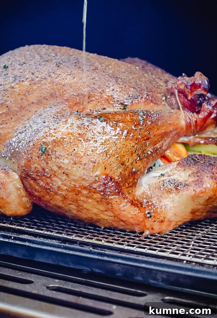 basting a turkey leg with melted butter inside of a smoker