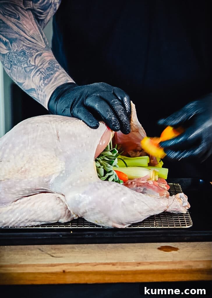 stuffing a smoked turkey with veggies and herbs