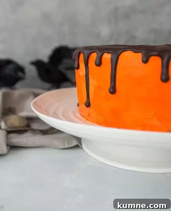black velvet cookies and cream cheesecake cake on a cake stand with fake blackbirds in the background