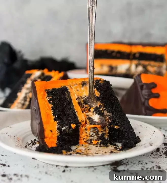 slice of black velvet cookies and cream cheesecake cake on a plate with a fork sticking out of it