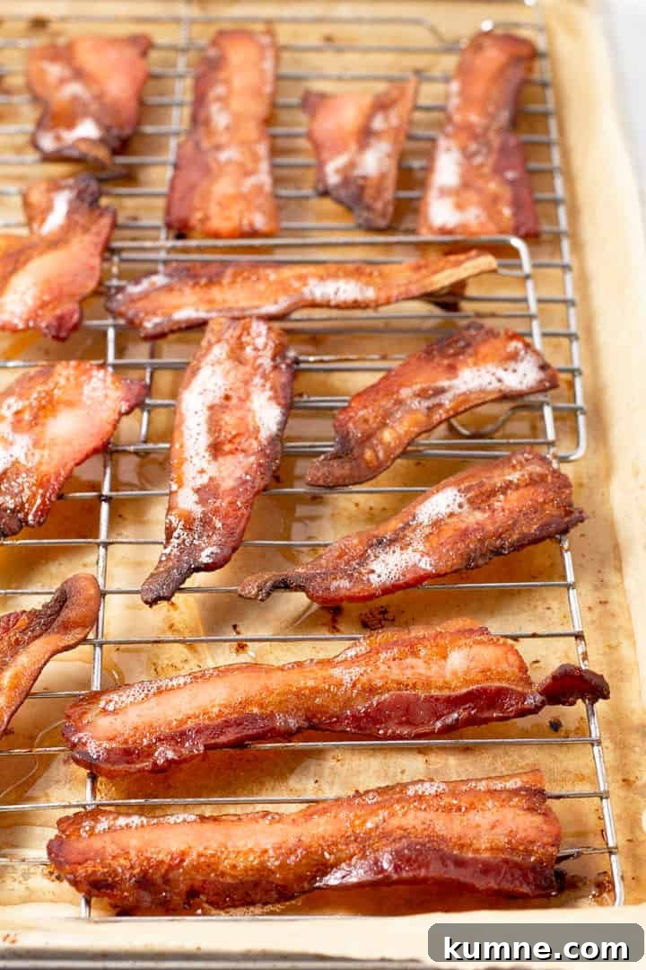 Loaded Baked Potato Dip Recipe for Parties and Game Day 3 Parchment lined baking sheet with a cooling rack on it with cooked bacon on top of it
