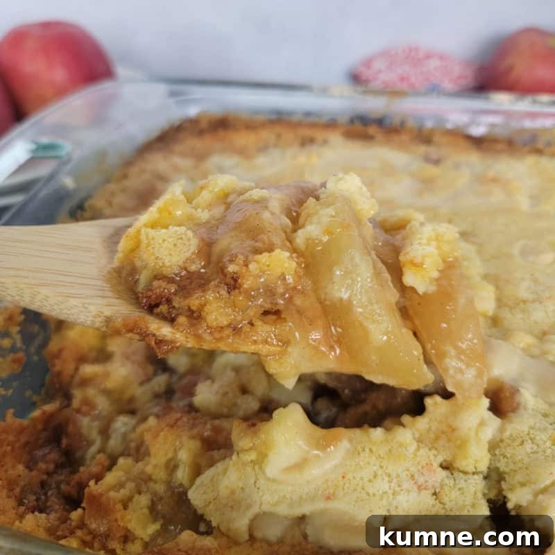 Top Fall Dessert Recipes You Need to Try This Season 23 Wooden Spoon scooping Caramel Apple Dump Cake from a glass pan